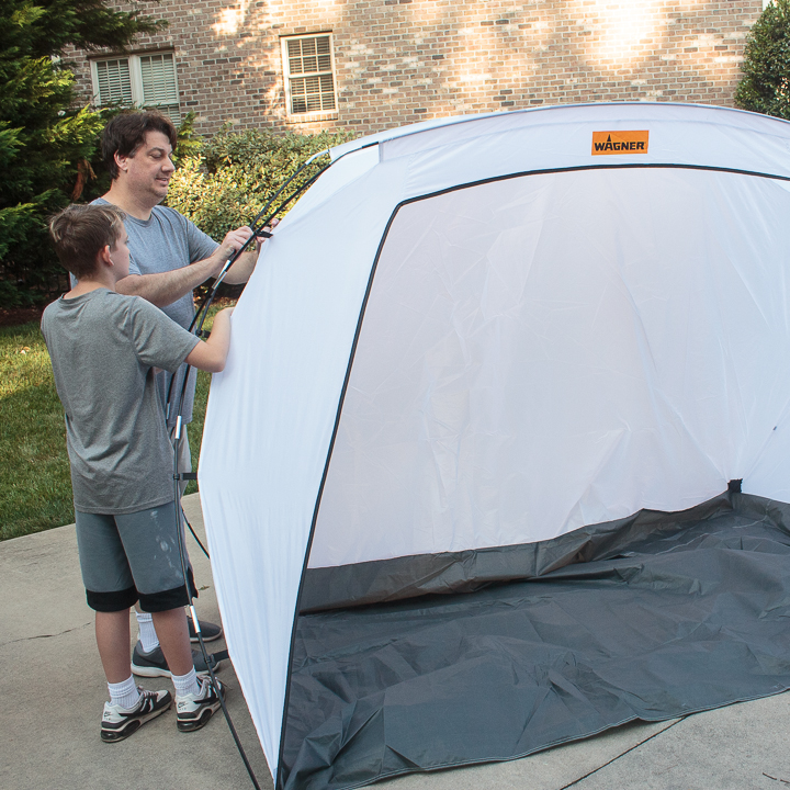 father and son putting up a spray shelter tent