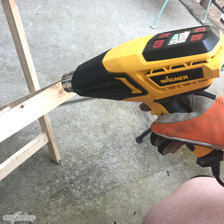 using a heat gun to create a burnt wood finish on a folding camp stool