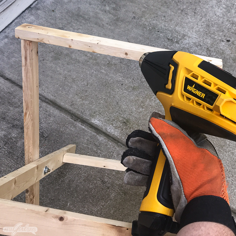 using a heat gun to create a burnt wood finish on a folding camp stool