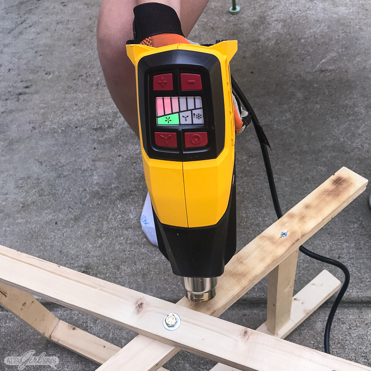 using a heat gun to create a burnt wood finish on a folding camp stool
