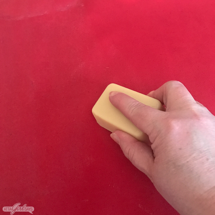 applying fabric wax to red canvas