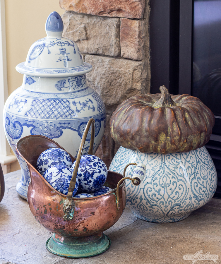 copper bucket filled with blue and white carpet balls as part of fall fireplace decor