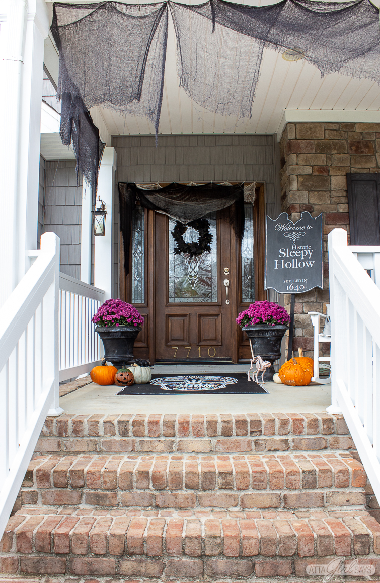 Spooky Halloween front porch with creepy cloth, pumpkins and a Sleepy Hollow sign