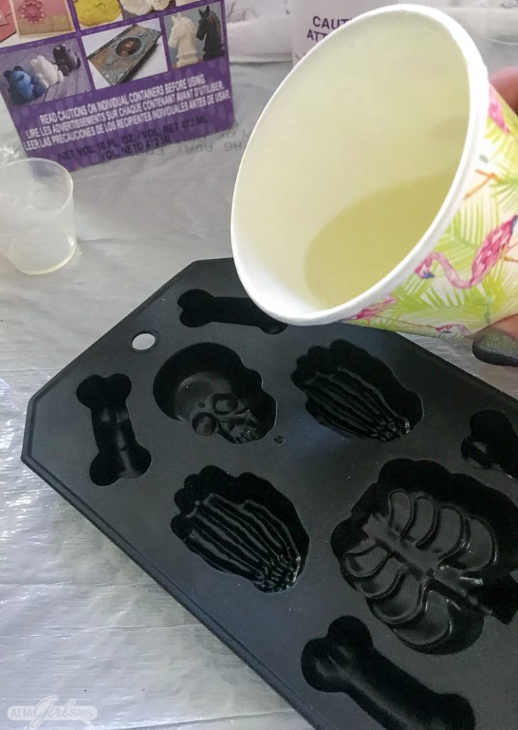 pouring liquid resin into a silicone ice cube tray