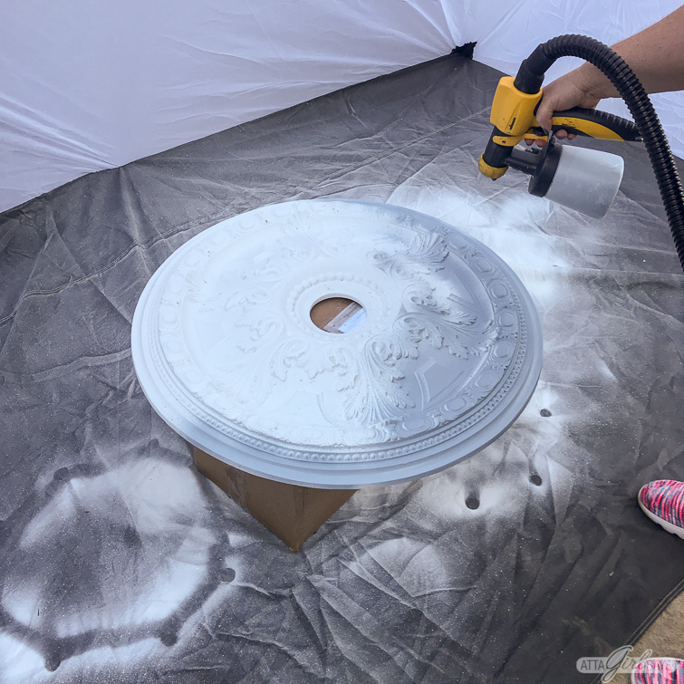 using a Wagner paint sprayer to paint a decorative ceiling medallion