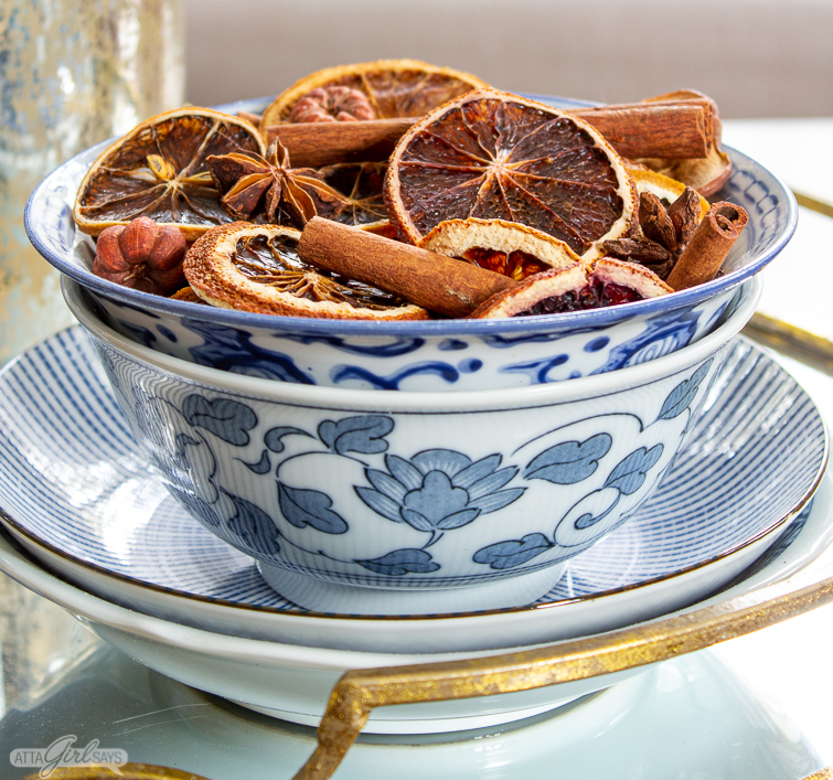 blue and white bowl filled with dried orange and cinnamon Christmas potpourri
