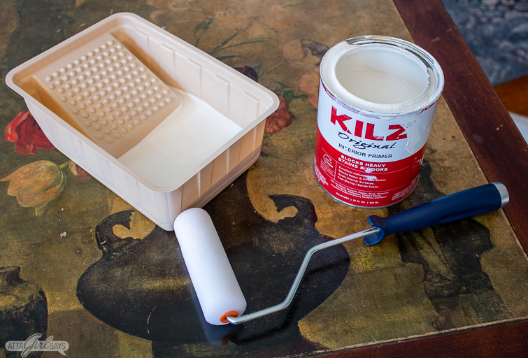 roller and can of KILZ primer on a floral tabletop