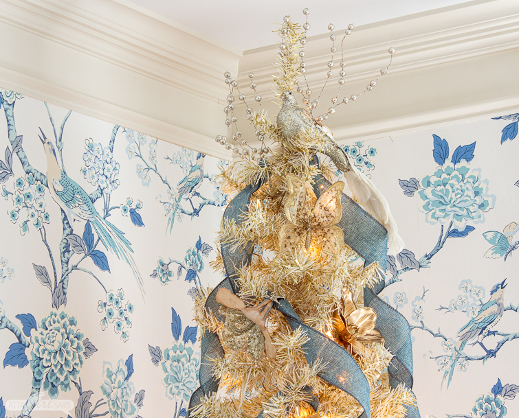 gold christmas tree with a glittery bird topper