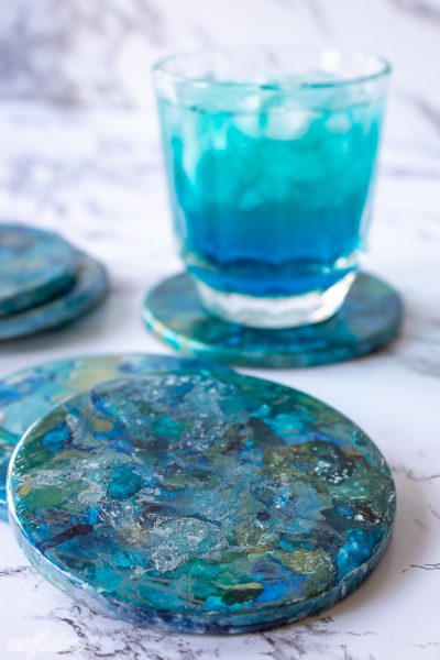 marbled alcohol ink coasters with a blue cocktail