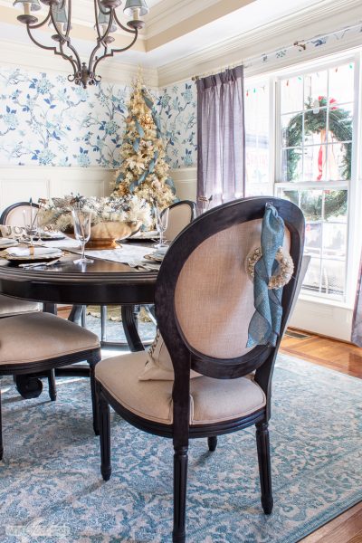 dining room with toile wallpaper, a gold Christmas tree and a formal table set for Christmas dinner