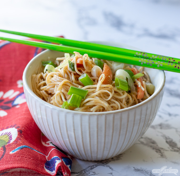 vegetarian cold sesame noodles in a bowl with green chopsticks