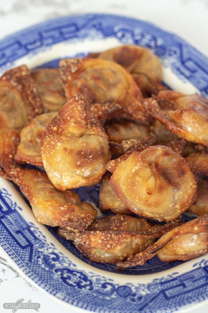 cirspy air fryer wontons on a blue willow plate
