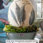 ostrich egg decorated with vintage fern leaf illustrations sitting in a silver bowl
