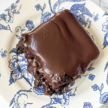 chocolate iced brownie on a blue and white floral plate