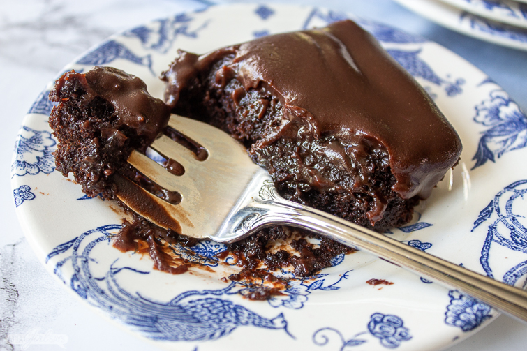 iced chocolate brownie and fork on a blue and white plate