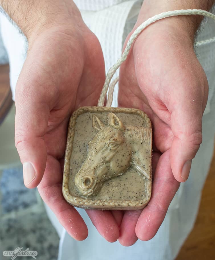 man in a bathrobe holding a bar of soap on a rope