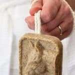 man in a bathroom holding soap on a rope