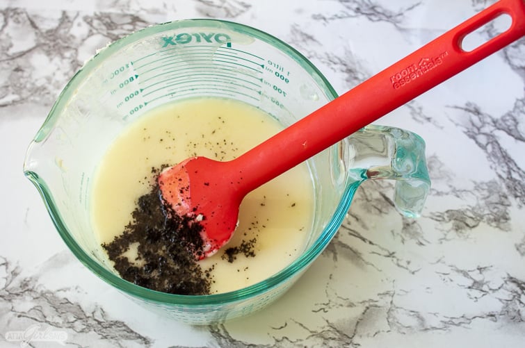 adding coffee grounds to melted goat's milk soap