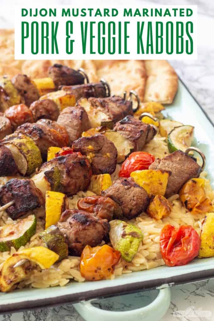 platter of pork and vegetable kabobs over orzo