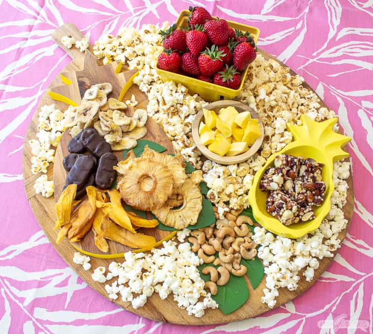 tropical charcuterie with fruit, popcorn, nuts and chocolate