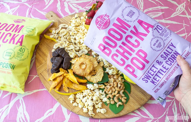 adding kettle corn to a tropical charcuterie board