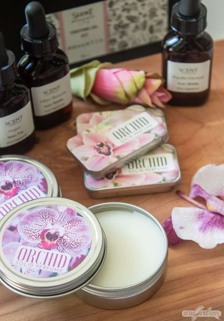 solid perfume in tins and fragrance oils on a wooden board