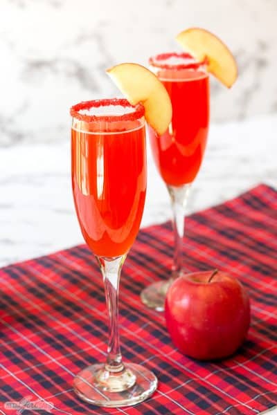 two cinnamon apple cider mimosa cocktails in champagne glasses