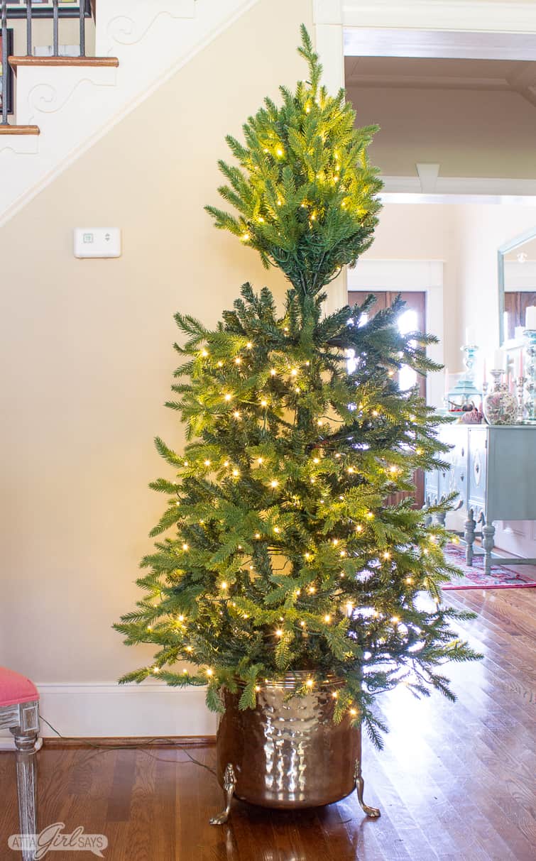 putting up an artificial tree in a vintage container