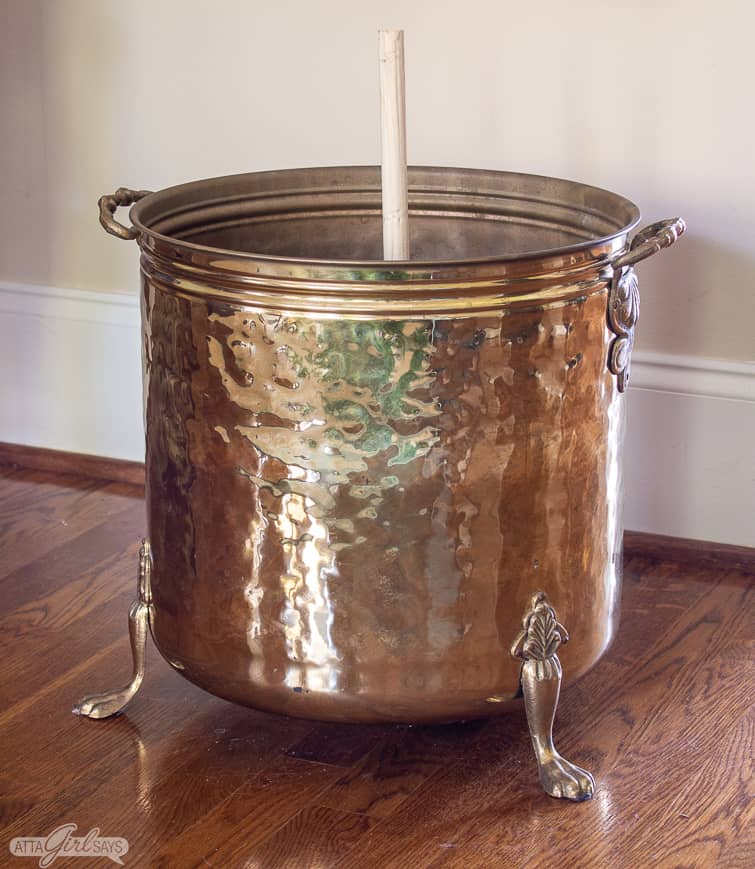 vintage brass planter with a wooden dowel rod mounted in the center