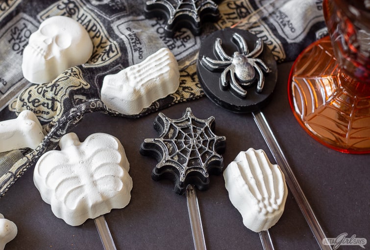 assorted Halloween cocktail stirrers on a black table