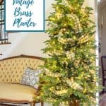 Christmas tree in a vintage brass planter beside a yellow French style settee