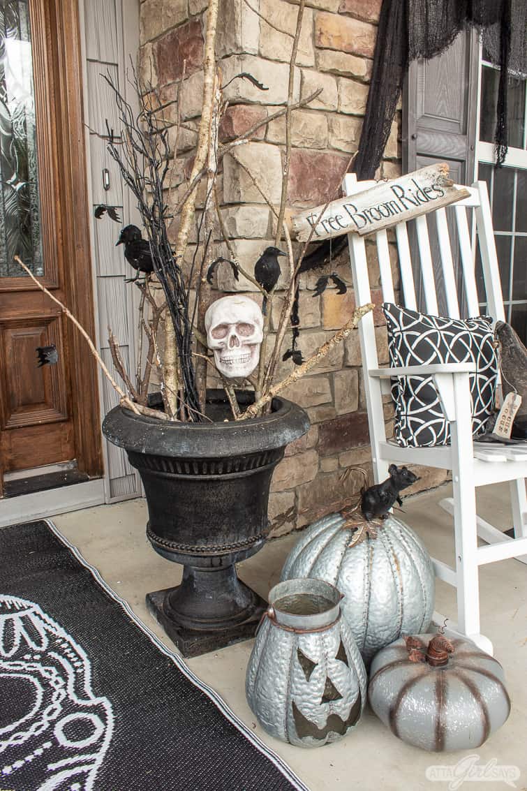 urn filled with sticks with pumpkins and skulls for Halloween