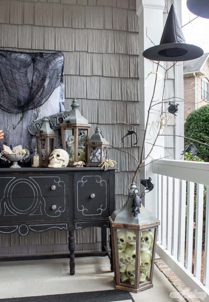 witch's hat hanging on a Halloween front porch beside a black buffet