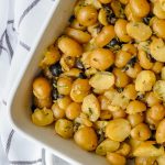 roasted potatoes with capers and olives in a white baking dish
