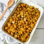 roasted potatoes with capers and olives in a white baking dish