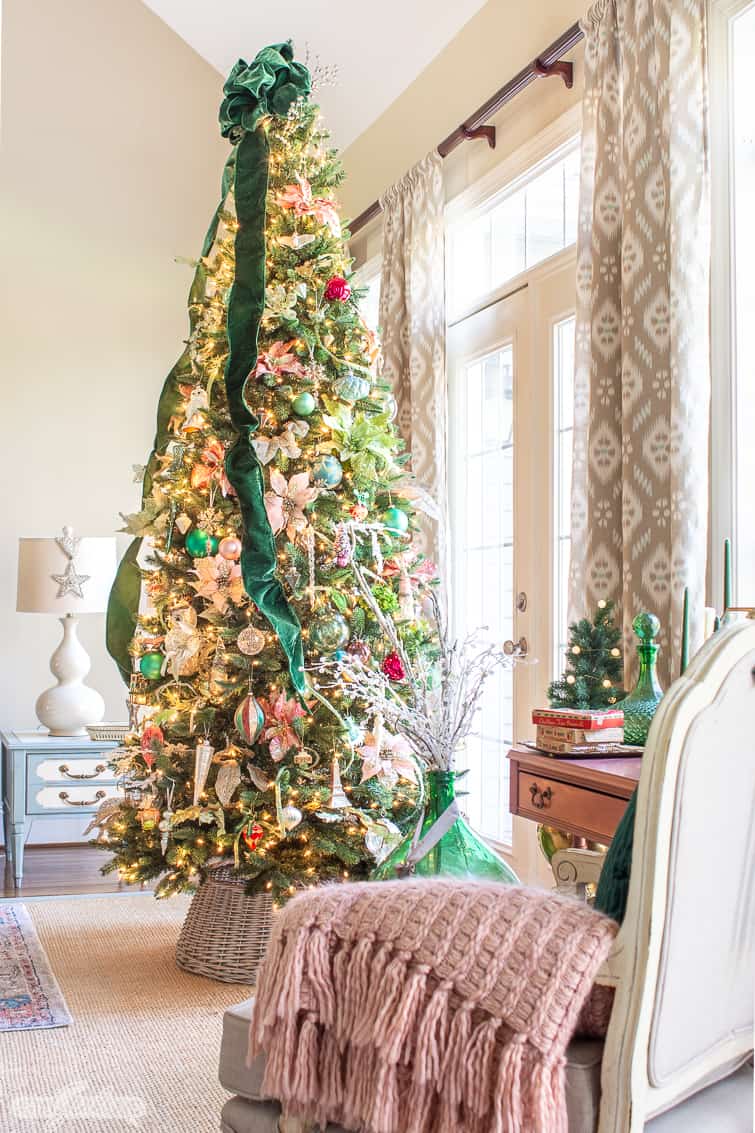 9 foot elegant Christmas tree decorated with glass ornaments and green velvet ribbon