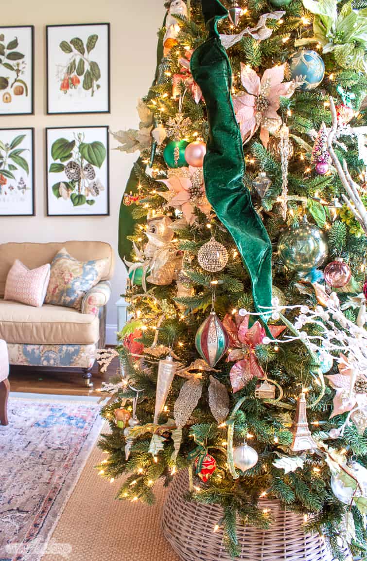 closeup of glass ornaments on a Christmas tree decorated with emerald green velvet ribbon
