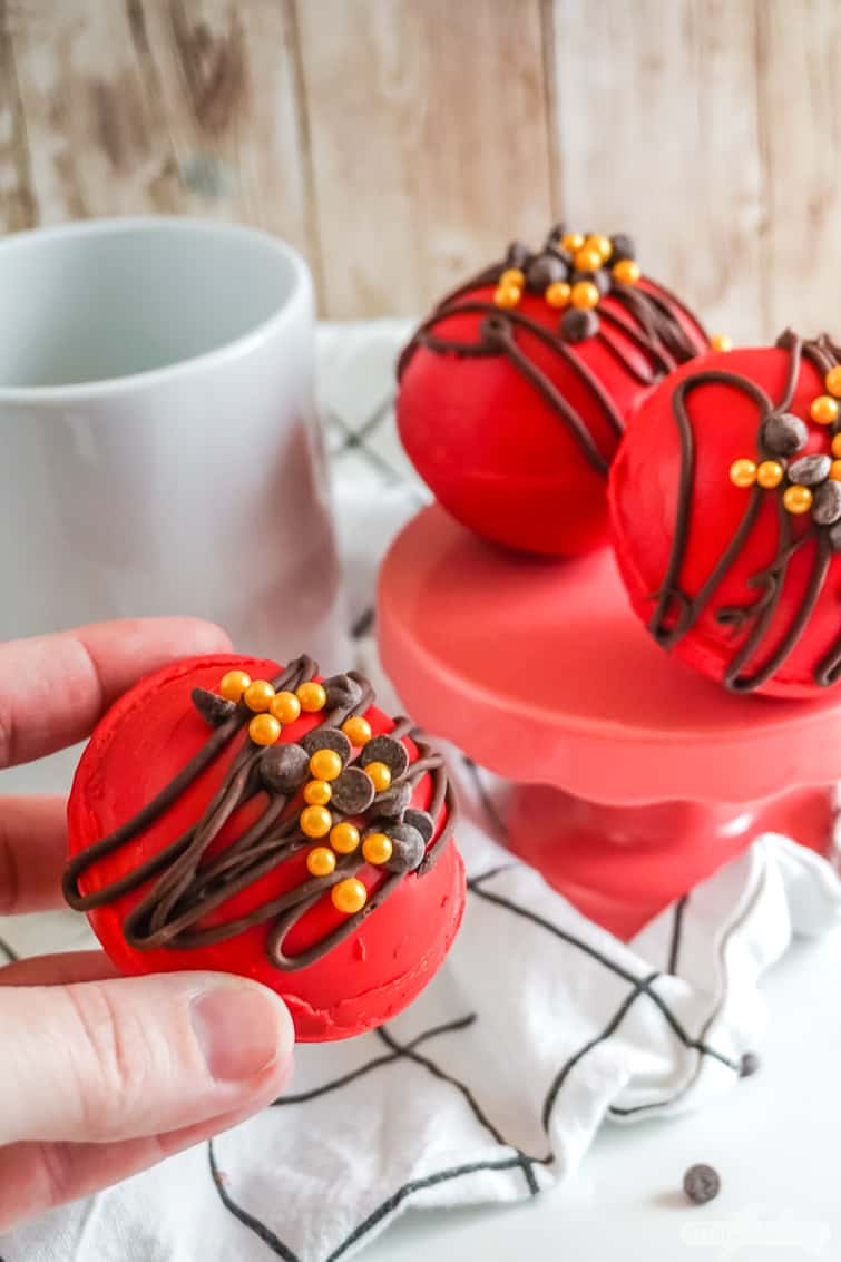 hand placing a hot chocolate bomb in a cup