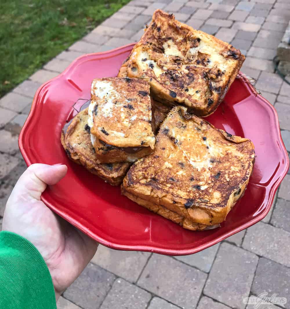 man carryling a plare of grilled toast outdoors