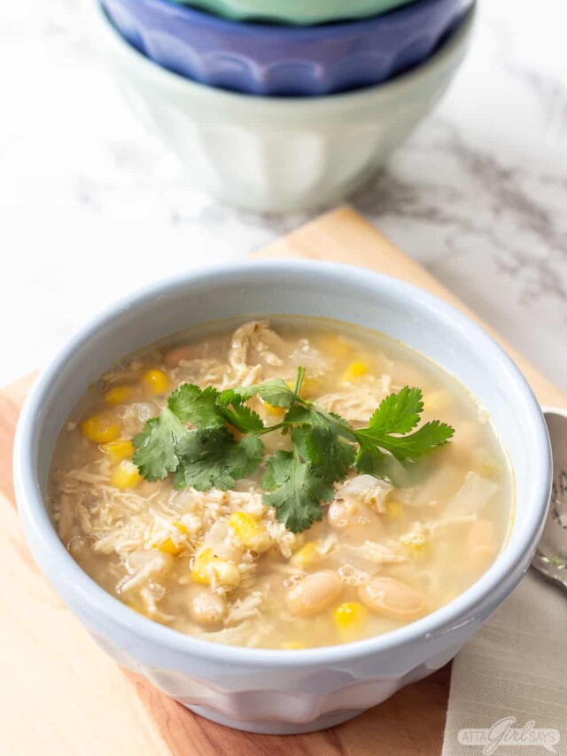 ceramic bowl of chicken chili with four more bowls in background