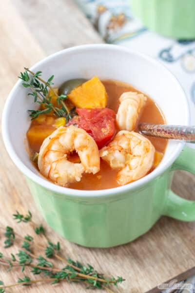 sweet potato shrimp chowder in a green bowl with a handle