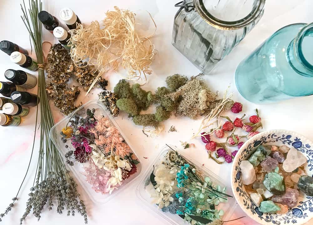 dried forals, herbs, moss and gemstones on a marble counter