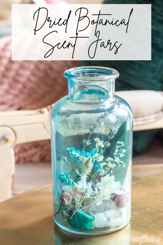 aqua blue glass jar filled with dried florals and gemstone rocks