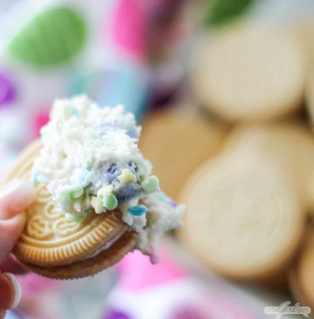 Golden Oreo cookie dipped in frosing with sprinkles
