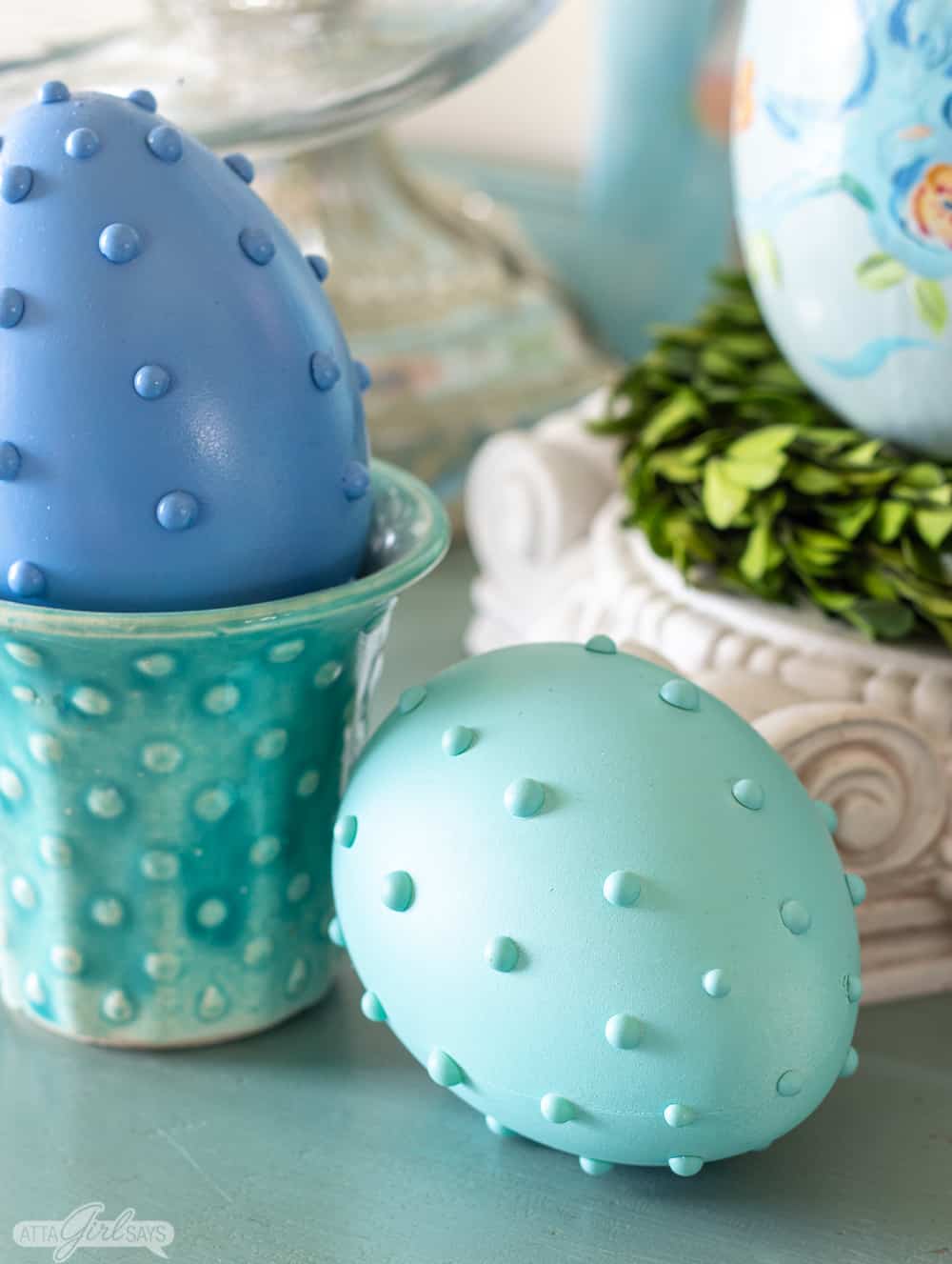 blue hobnail Easter egg in an aqua vintage McCoy planter with a green egg beside it