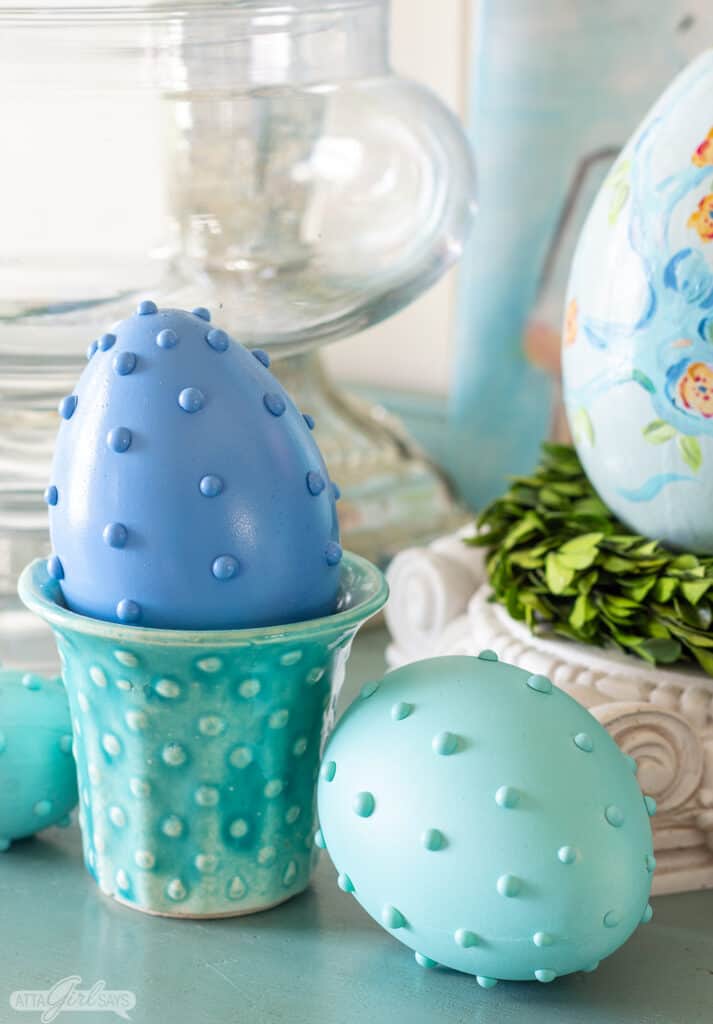 blue hobnail Easter egg in an aqua vintage McCoy planter with a green egg beside it