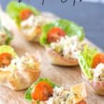 baked wontons filled with chicken salad on a wooden board