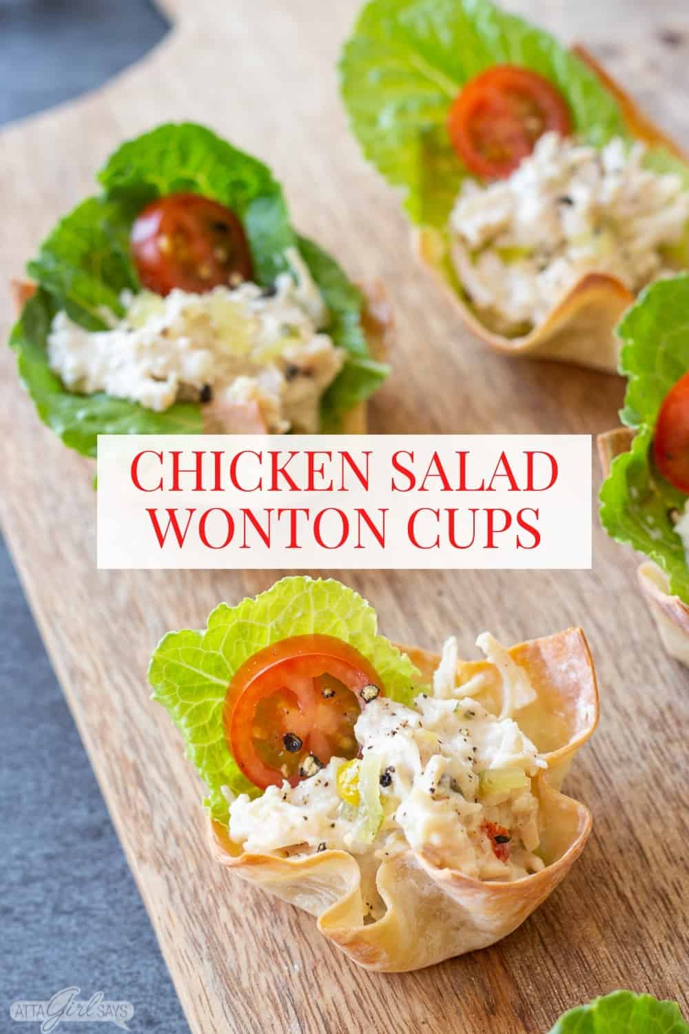 chicken salad wonton cups with lettuce and tomato on a wooden board