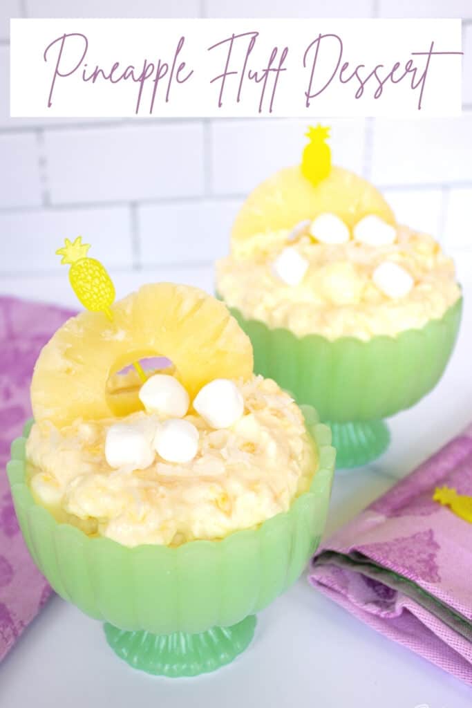 pineapple fluff garnished with marshmallows and pineapple ring in a green jadeite compote bowl