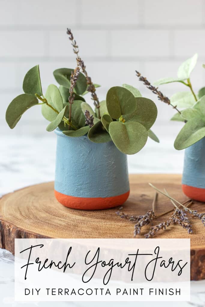 DIY painted French yogurt jar with greenery on a wooden charger